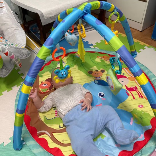 bebe heureux dans tapis eveil sensoriel colore