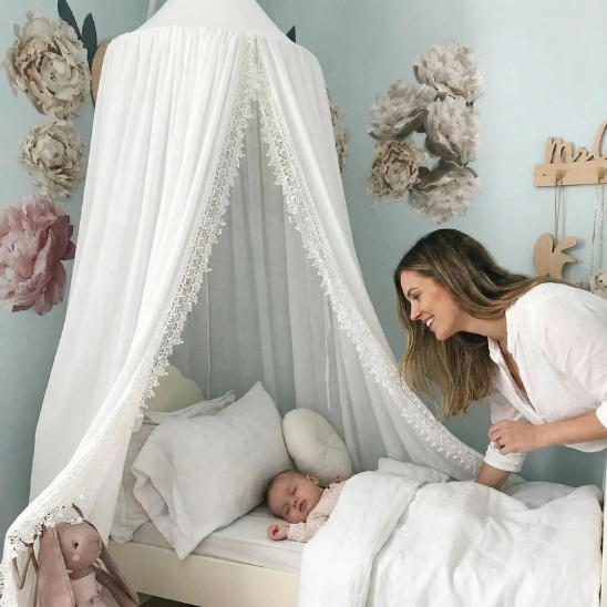 ciel de lit bebe blanc dentelle maman souriante avec son bambin