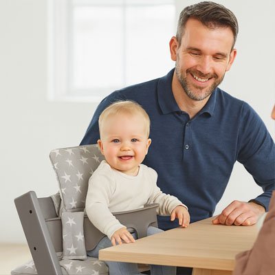 papa et bebe souriants chaise haute coussin comfortbaby
