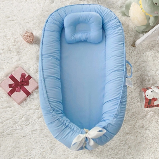 reducteur de lit bebe bleu pastel confort doux sur tapis