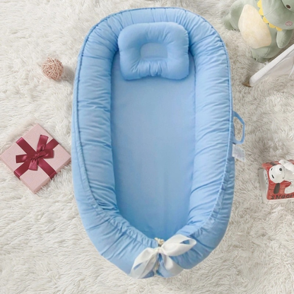 reducteur de lit bebe bleu pastel confort doux sur tapis